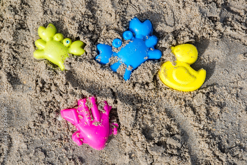 Children's beach toys - buckets, spade and shovel on sand on a sunny day Children's beach toys - buckets, spade and shovel on sand on a sunny day