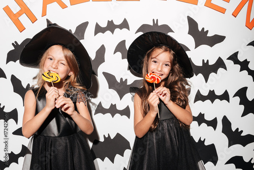 Couple of two smiling little girls dressed in halloween costumes