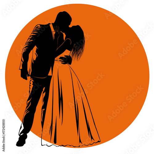 Silhouettes of kissing bride and groom against an orange circle