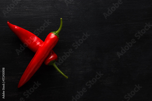 Red hot chili pepper on a dark background with space under the text