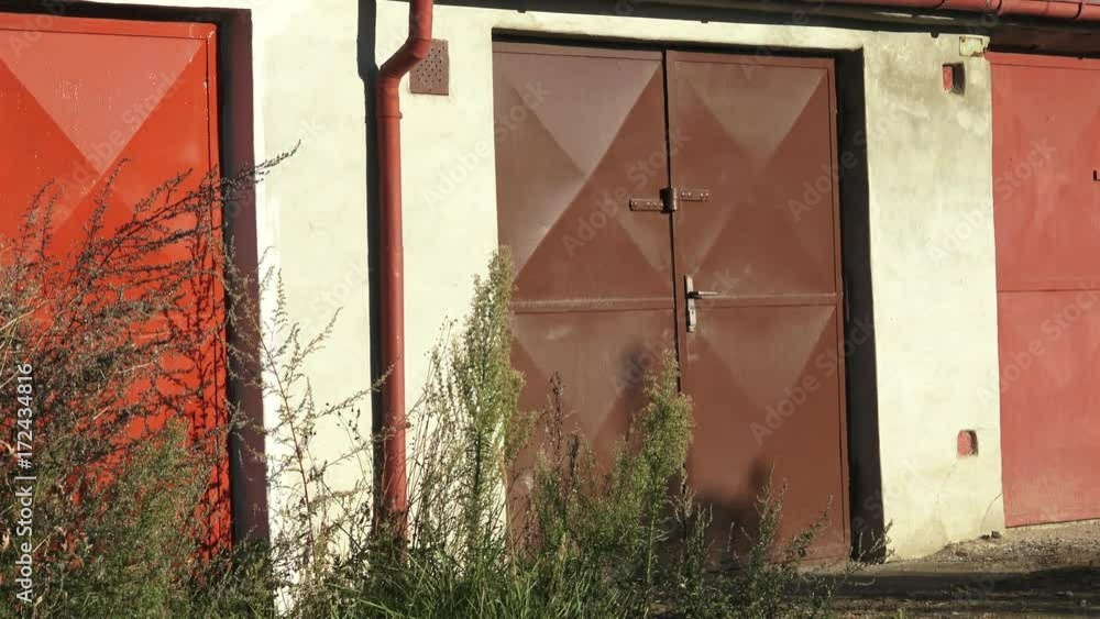 The aged gates of old garages. Old worn abandoned garages. Old metal