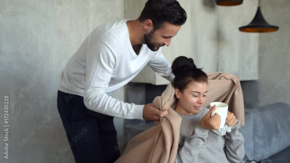 Loving millennial man covering ill wife with blanket Loving millennial man covering ill wife with blanket