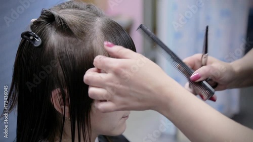 Hairdresser makes hairstyle for young girl