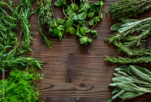 drying fresh herbs and greenery for spice food on wooden kitchen desk background top view space for text