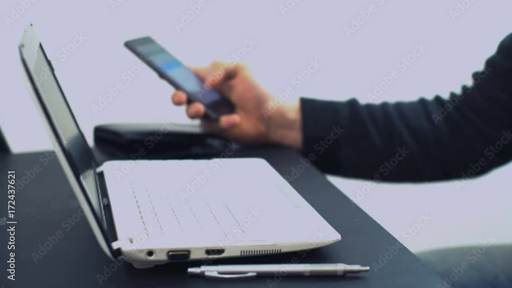 A man (Man's hands), an office worker, sits at home outside his time using a laptop and a bank credit card, pays for online payment in an online store.