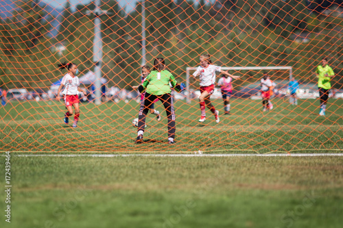 Young female soccer goalie in the net getting ready for a save during the attack