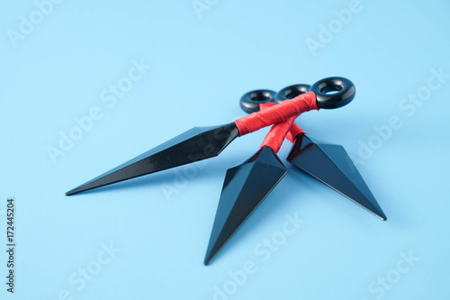 To throw ninja weapons isolated on blue paper background photo