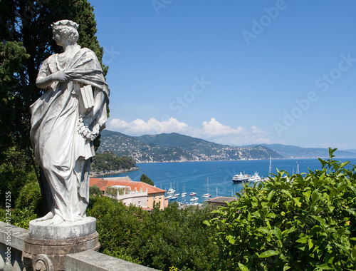 Ancient Status Overlooking Bay with Boats