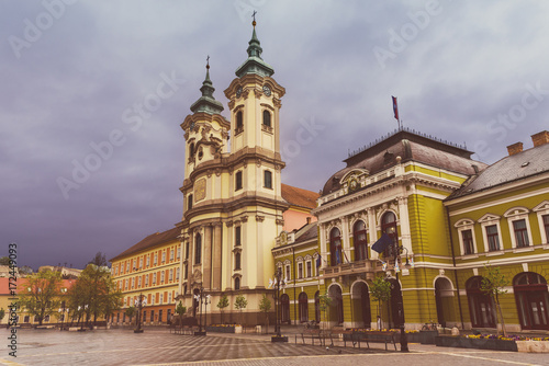Eger main square in Hungary, Europe with dark moody sky and catholic cathedral. Travel outdoor european background © Roxana