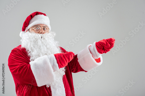 Cheerful Santa Claus showing something by gesture