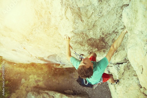 Rock climber climbs on a rocky wall.