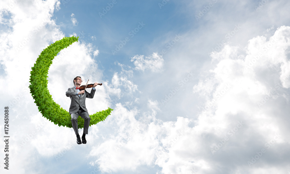 Handsome violinist on moon in blue sky play his melody Handsome violinist on moon in blue sky play his melody