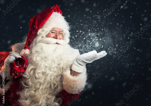 Santa Claus blowing magic snow of his hands photo