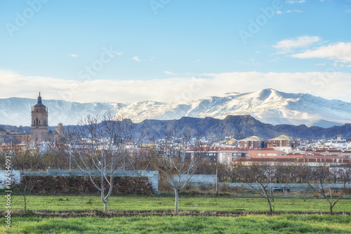 View of the town Guadix and Cathedral with the snow capped mountains of the Sierra Nevada, Granada Province, Andalucia, Spain.