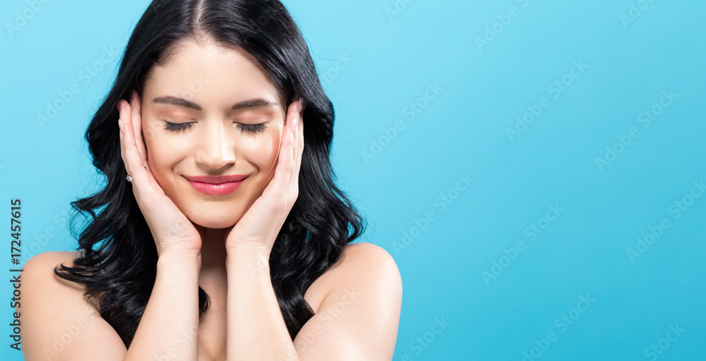  Beautiful young woman touching her face in skin care theme - obrazy, fototapety, plakaty 