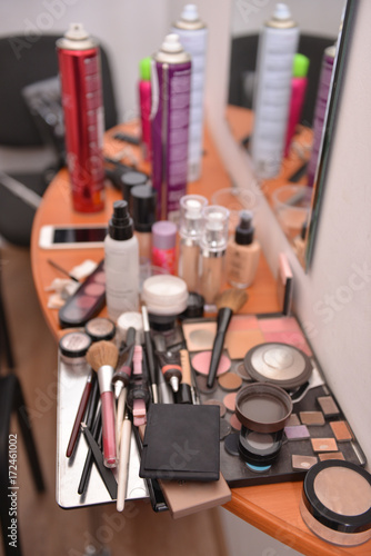 makeup products are lying on the table while the stylist is working. backstage.