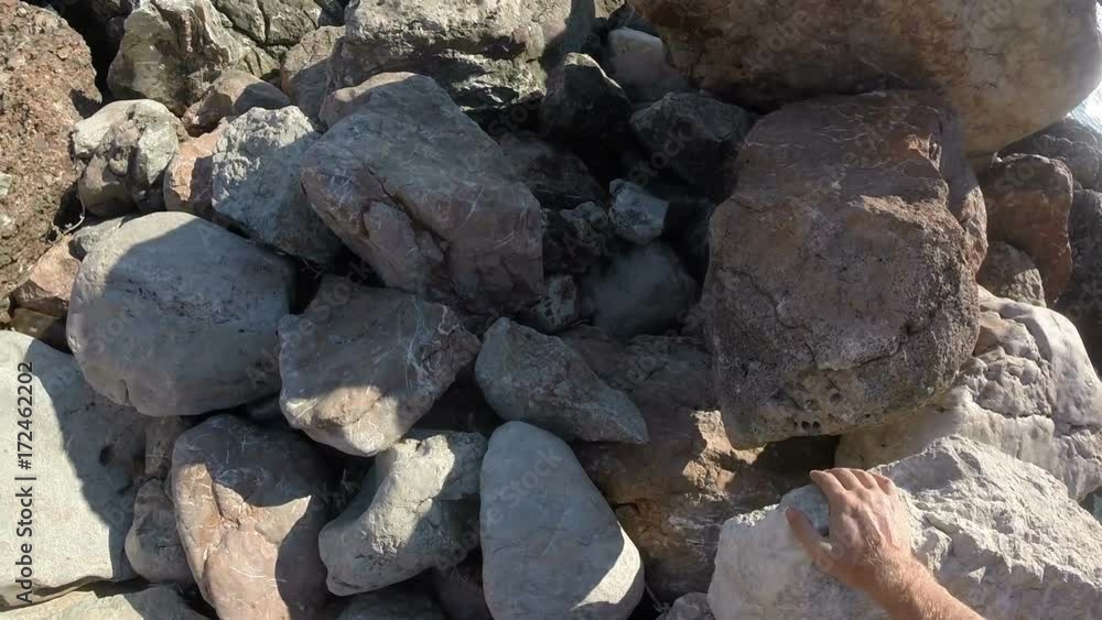 A person walks along large rocks enjoying the view of the sea. Shooting from the first person. Sea view in the background. A person walks along large rocks enjoying the view of the sea. Shooting from the first person. Sea view in the background.