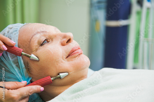muscle toning procedure for senior woman in cosmetology clinic