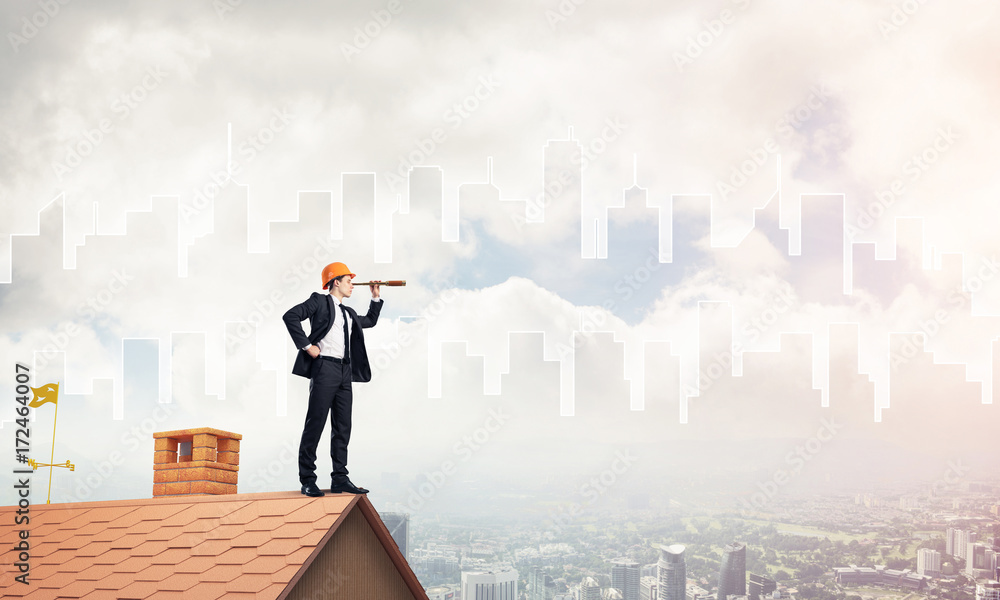 Engineer man standing on roof and looking in spyglass. Mixed med Engineer man standing on roof and looking in spyglass. Mixed med