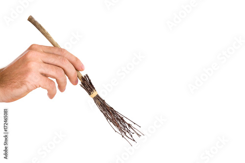 Ancient natural, old wooden broom created from tree branches, which wiped rooms, yards and streets. Autumn leaf sweeping. Janitor's hand holding a small work tool. Isolated on the white background.