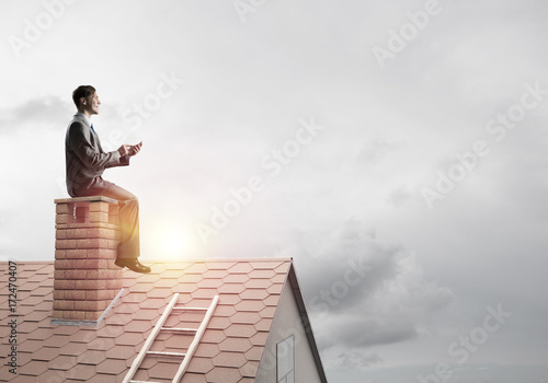Businessman or student on brick roof smiling and making calls