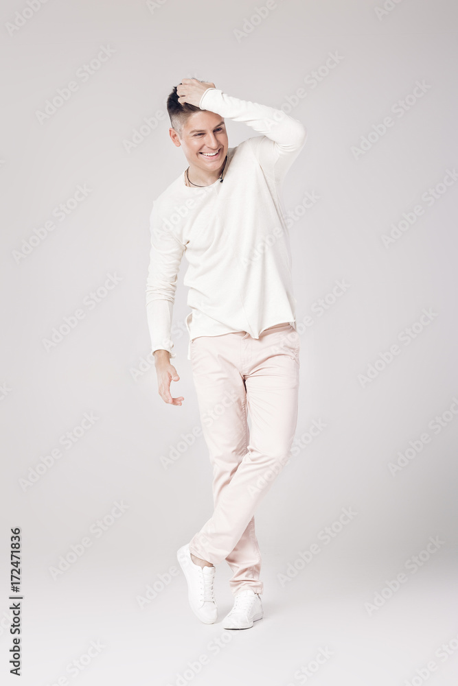 handsome young man in a white sweater and pants handsome young man in a white sweater and pants