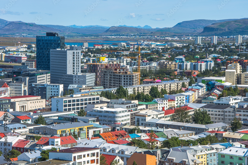 Beautiful super wide-angle aerial view of Reykjavik, Iceland with harbor and skyline mountains and scenery beyond the city, seen from the observation tower of hallgrimskirja