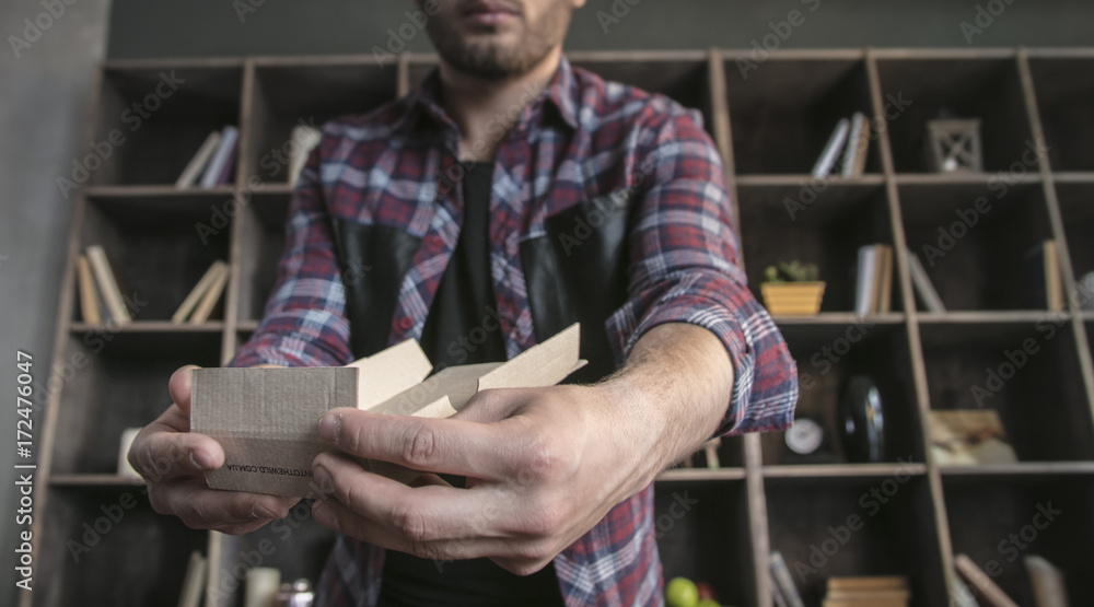 Young man designer manually assemble small packaging cardboard box for products Young man designer manually assemble small packaging cardboard box for products