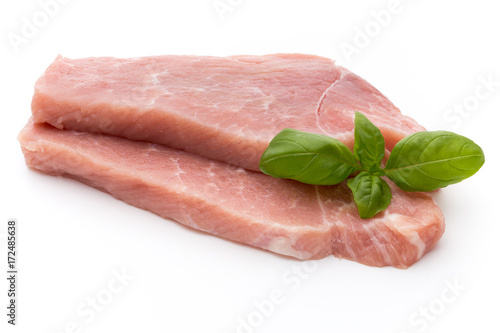 Fresh pork fillet with basil on a white background.