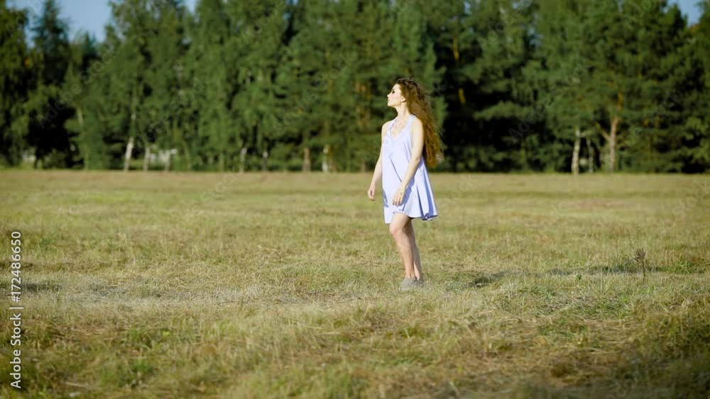 Incredible beautiful woman wondering around in field alone enjoying the last summer days and being happy Incredible beautiful woman wondering around in field alone enjoying the last summer days and being happy