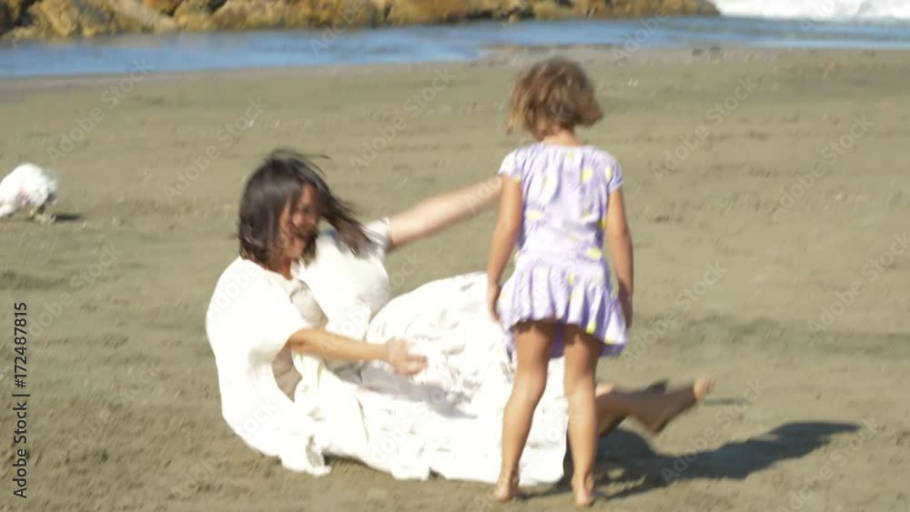 Mother and little daughter hugging and playing on beach happy 4K slow motion Mother and little daughter hugging and playing on beach happy 4K slow motion