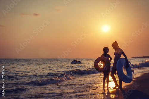 Photography Alanya, Turkey -  September 14, 2017: two young girls on sea beach at sunset