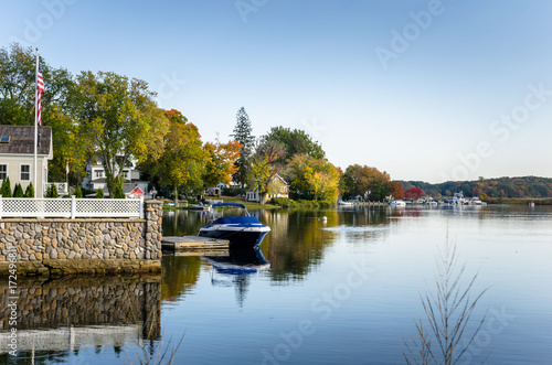 Waterside Houses with Boats Moored to Wooden Jetties and Clear Blue Sky.