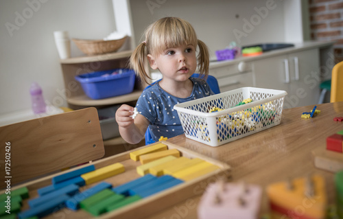 Little blonde girl is playing at kindergarten