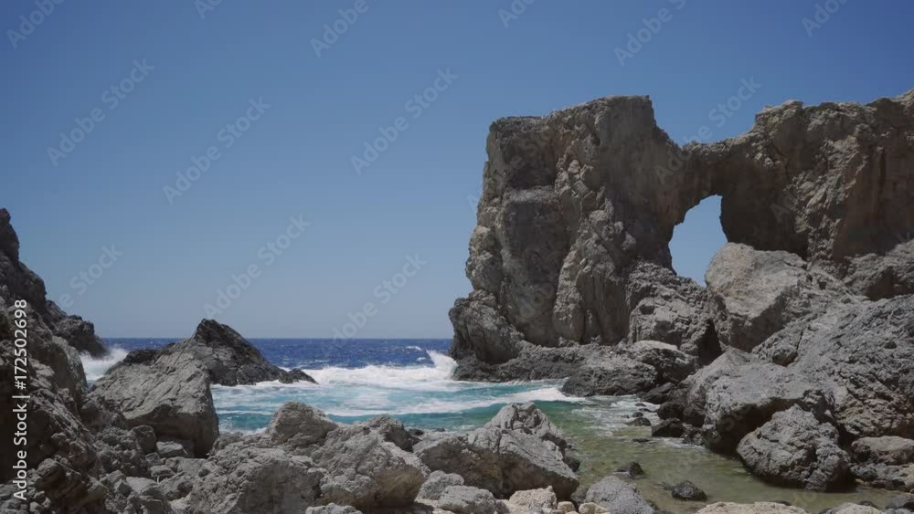 Rocky Beach with Big Cliffs And Waves Crashing On A Bright Summer Day In Antikythera, Greece. Rocky Beach with Big Cliffs And Waves Crashing On A Bright Summer Day In Antikythera, Greece.