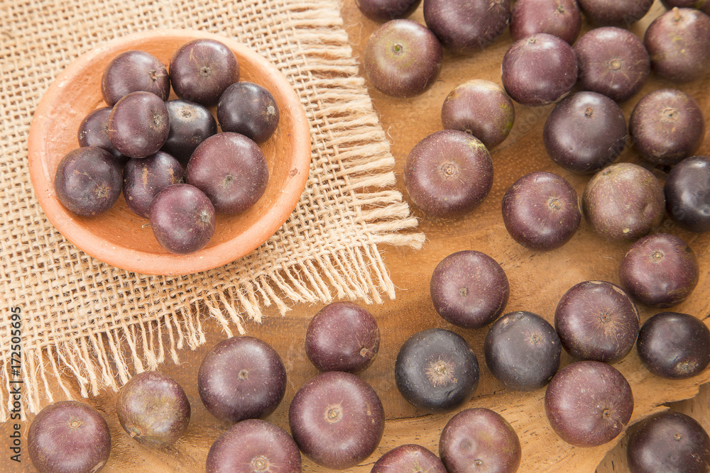 Fototapeta premium Jaboticaba (brazilian berry) on wooden table (Plinia cauliflora)