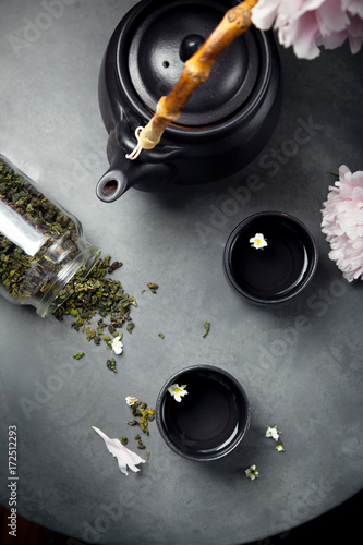 Two cups of Oolong tea with teapot and peionies, overview