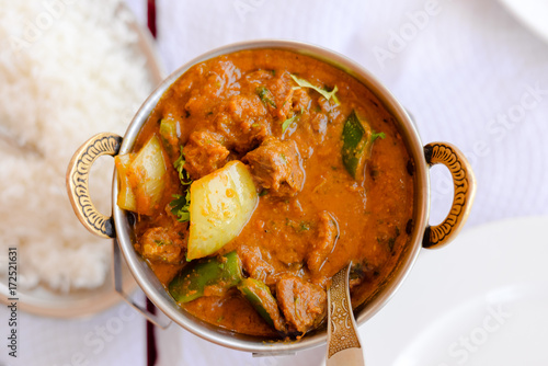 Closeup on Indian speciality curry dish over light restaurant table background. Traditional maincourse delicacy photo