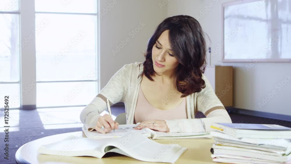 Student studying and taking notes with textbooks Student studying and taking notes with textbooks