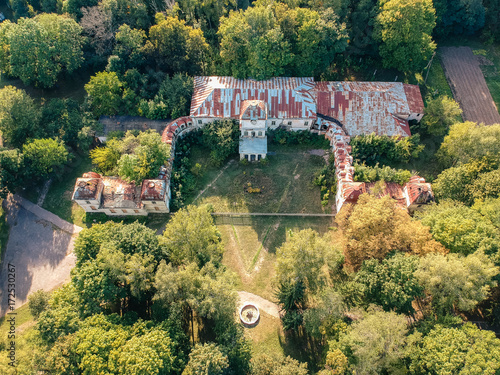 Aerial view on ruins of abandoned mansion in summer sunset lights.  photo