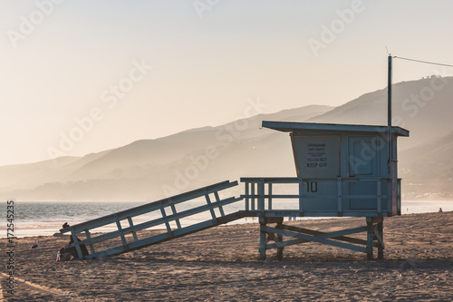 A lifeguard station with a foggy background and mountains on Zuma Beach in Malibu, California. 