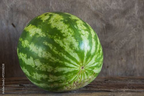 Whole watermelon on the wooden background