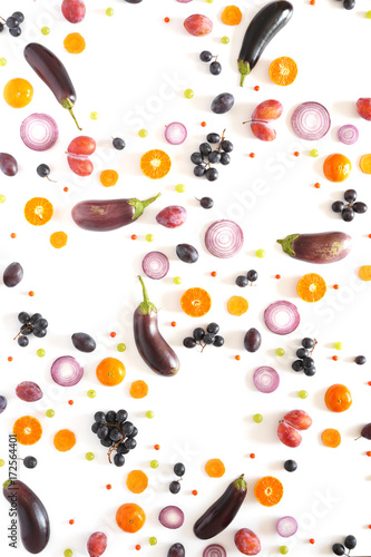 Fototapeta Composition of vegetables and fruits on a white background. Pattern made from fresh vegetables and fruits. Top view, flat design. Collage of red cabbage in a cut, eggplants, plums, grapes, mandarins.