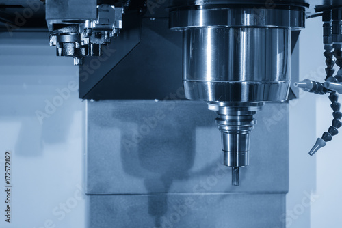 Close up of the CNC spindle with the cutting tool and holder in the light blue scene.The CNC machining center for hi-technology manufacturing. photo