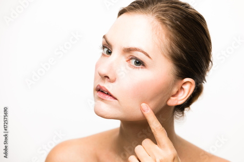Billede på lærred Caucasian woman who checks her skin. acne treatment.