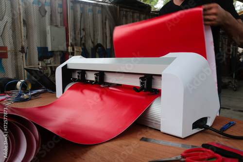 Sticker machine and red sticker sheet ready to cutting stickers for use different types of jobs.