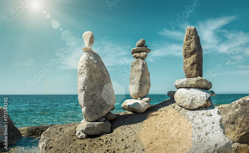 Composition of stones on the seacost under blue sku with clouds photo