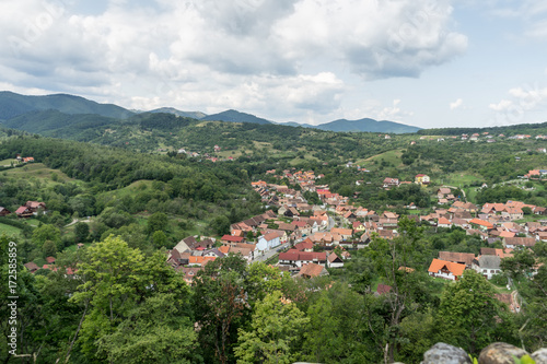 View of Cisnadie town from the castle wall of Cisnadioara fortified medieval church, in Sibiu, Transylvania, Romania. Cloudy summer day