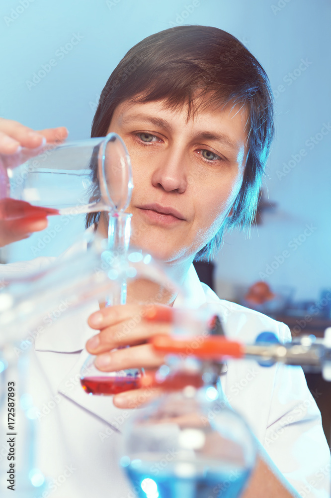 Female scientist in white coat working in a chemical laboratory Female scientist in white coat working in a chemical laboratory