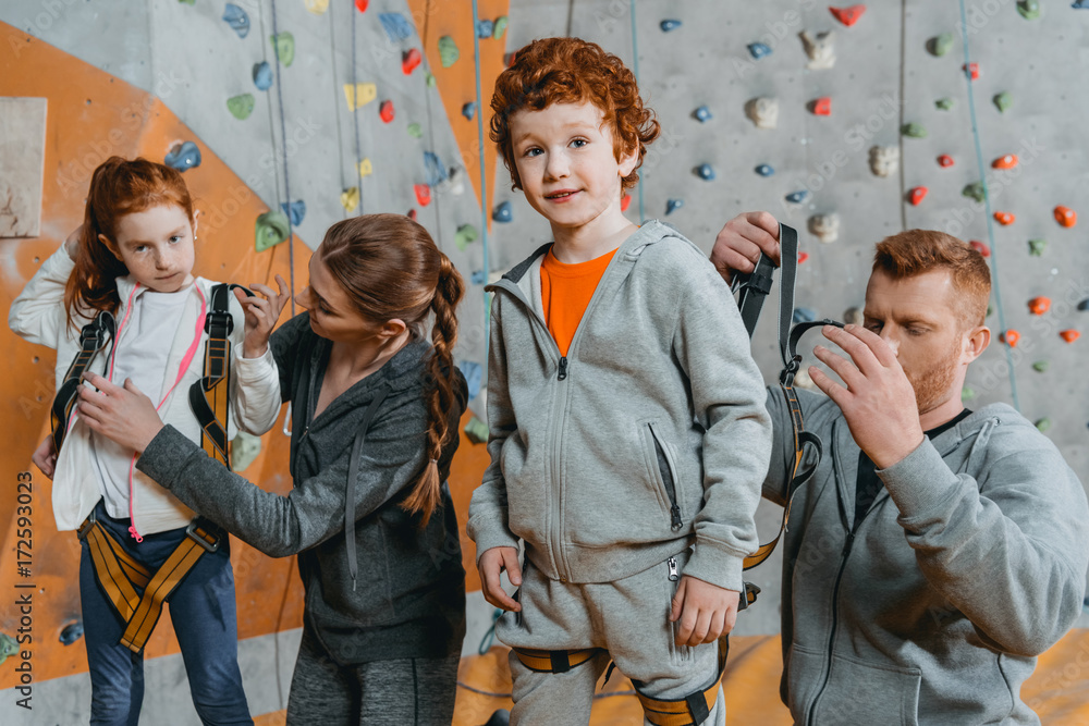 Parent securing children in harnesses StockFoto Adobe Stock